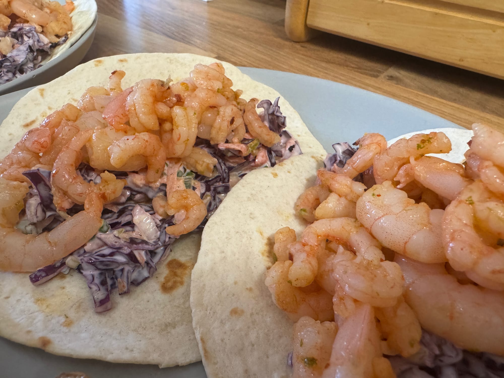 Assembled prawn tacos topped with avocado and coriander