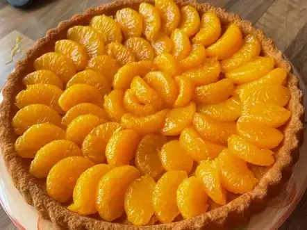 A Mandarin flan with sliced oranges on top, creating a vibrant and citrusy dessert.