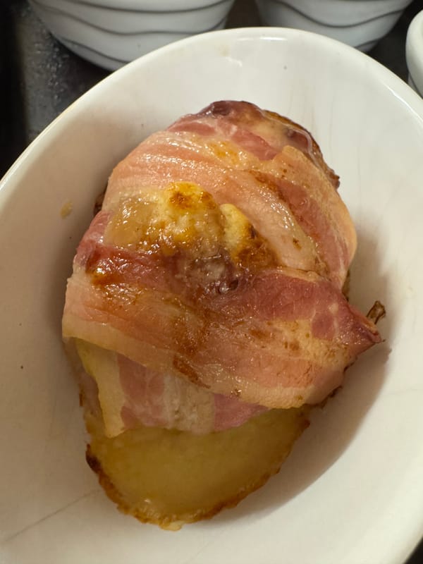 Bacon-wrapped Camembert jacket potatoes, ready to serve.