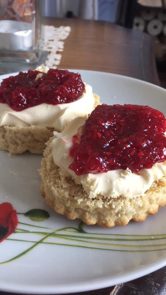 Two delectable scones elegantly rest upon a pristine plate, exuding an irresistible aroma of freshly baked goodness.